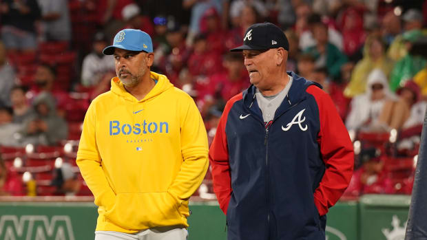Jul 25, 2023; Boston, Massachusetts, USA; Boston Red Sox manager Alex Cora (13) and Atlanta Braves manager Brian Snitker (43) meet on the field during a rain delay before the start of the game at Fenway Park.